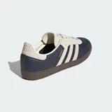 Championes Adidas Samba OG, color azul marino con detalles en beige y suela marrón. Diseño clásico de cuero y gamuza con las tres tiras laterales características de la marca.