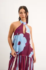 Vestido largo sin mangas, con escote halter y abertura en el pecho, corte holgado y diseño combinado de estampa abstracta floral en la parte superior y rayas verticales traslúcidas en la falda.