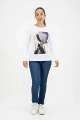 Remera de manga larga color blanco con cuello redondo y estampa abstracta central en tonos oscuros y neutros.