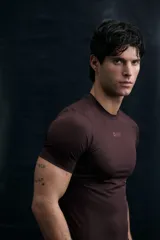 Remera deportiva de compresión con tecnología DryMove, diseñada para absorber el sudor y brindar soporte muscular. Presenta cuello redondo, mangas raglán con costuras planas antifricción y estampado frontal pequeño.