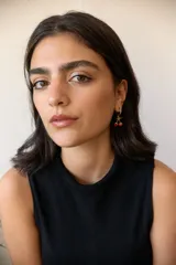 Aros dorados tipo argolla con dije de cerezas rojas colgando.