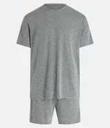 Pijama corto de hombre confeccionado en malla flameada de color gris con efecto mezcla, compuesto por una remera de manga corta con cuello redondo y un short con cintura elástica.