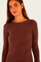 Vestido largo de punto color marrón, con diseño estampado de hojas en tono sutil, cuello redondo, mangas largas acampanadas y corte recto hasta los tobillos.
