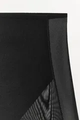 Shorts tipo ciclista de tiro alto con cintura elástica, confeccionado en poliamida con paneles laterales y frontales de tejido mesh. Presenta un diseño con efecto reductor que estiliza la figura.
