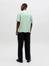 Camisa de manga corta color verde menta, con cuello cubano y cierre frontal con botones.