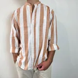 Camisa de lino con diseño de rayas verticales en color blanco y tostado, cuello mao y cierre frontal con botones.