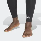 Calza de compresión Adidas Techfit color negro, con cintura elástica con logo de la marca y tecnología AEROREADY para absorción de humedad. Presenta paneles de malla para mayor ventilación y un panel frontal esculpido en 3D.