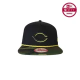 Gorra New Era 9FIFTY negra con visera de camuflaje y logo del equipo de béisbol Cincinnati Reds bordado en dorado.