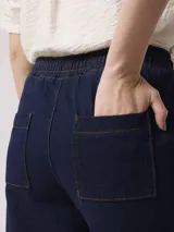 Pantalón de denim azul oscuro, de corte amplio y largo cropped.