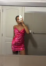 Vestido corto ajustado color rosa con estampado animal print en tonos fucsia y rosa más claro. Presenta escote drapeado tipo cowl neck y tirantes finos ajustables.