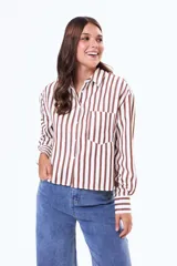 Camisa de corte recto y holgado con estampado de rayas verticales en color marrón y blanco. Presenta cuello clásico, cierre frontal con botones, manga larga con puños abotonados y un bolsillo aplicado en el pecho.