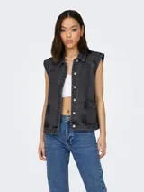 Chaleco de denim color negro lavado, con cuello camisero, cierre frontal con botones metálicos y bolsillos laterales. Presenta un diseño sin mangas con hombros estructurados.