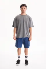 Remera oversize gris oscuro con efecto lavado, cuello redondo y mangas cortas amplias.