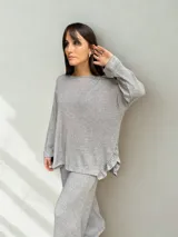 Buzo gris de lanilla con lurex, corte holgado y volados en los laterales inferiores.