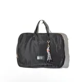 Cartera tipo sobre color negro, con cierre superior y manijas cortas. Incluye un dije de cuerdas de colores.