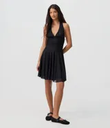 Vestido corto negro de encaje con diseño halter, escote profundo en V, cintura ajustada fruncida y falda con vuelo. Cuenta con forro interior.