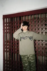 Crewneck de rústico piqué color verde militar con estampado en el frente y la espalda. Mangas ranglan.