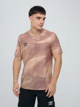 Remera deportiva Umbro modelo Niso, de manga corta y cuello redondo, con estampado abstracto en tonos negro y gris, y logo de la marca impreso en el pecho.
