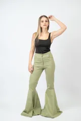 Pantalón negro de tiro alto con corte acampanado y terminación en volado en el ruedo.