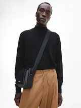 Sweater negro de cuello perkins confeccionado en lana merino extrafina. Tiene cuello, puños y bajo de canalé.