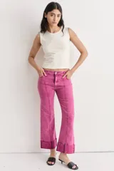 Jean de mezclilla azul oscuro con costuras contrastantes marcadas en el frente y dobladillo ancho vuelto en el ruedo.