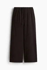 Pantalón de punto de algodón color negro, con cintura elástica y cordón ajustable, de perneras rectas y bolsillos laterales discretos.