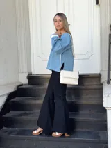 Camisa celeste de jean con cuello en V, mangas largas abullonadas con puños de encaje y cierre frontal con botones.