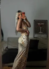 Vestido midi de dos piezas con estampado de piel de serpiente, compuesto por un top tipo halter con detalle metálico frontal y una falda ajustada de tiro alto.