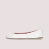 Bailarinas de charol blanco con lazo ajustable en la puntera, suela de goma antideslizante, plantilla de piel con memory foam y forro de tela.