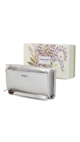 Billetera de mujer tipo sobre con correa de mano extraíble, confeccionada en material texturizado color tostado. Presenta un bolsillo frontal con cierre, compartimentos internos para tarjetas y logo de la marca grabado en el frente.