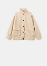 Chaqueta de algodón estilo denim, de diseño oversize, color beige, con cuello alto, manga larga, bolsillos de parche con solapa y cierre frontal de botones oscuros.