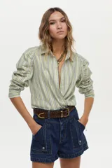 Camisa de lino y viscosa con diseño a rayas verdes y azules, cuello camisero, manga larga raglán con fruncidos y corte cruzado en el frente.