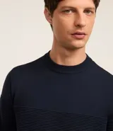 Suéter de punto para hombre con cuello redondo y manga larga. Presenta un diseño combinado con una parte superior lisa y una parte inferior con canalé texturizado horizontal. Marca Marfinno.