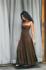 Vestido midi de corte fluido con cuello halter y lazada ajustable. Presenta escote recto y falda con volumen.