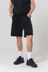 Bermuda cargo de algodón negro con calce relajado, bolsillos laterales aplicados y diseño utilitario.