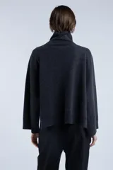 Sweater de lana superfina color gris, con corte holgado, mangas largas y cuello alto con medio cierre lateral.