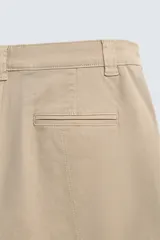 Pantalón cargo de corte relajado confeccionado en tejido de algodón con elasticidad. Presenta bolsillos laterales tipo cargo con solapa en las perneras, bolsillos frontales y bolsillos traseros de doble vivo. Cierre frontal con cremallera y botón.