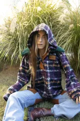 Buzo oversize con capucha, confeccionado en paño de lana con estampado de cuadros en tonos violeta, negro y naranja. Presenta cuello con cierre de botones y detalles en cuero sintético.