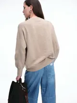 Sweater de tejido de punto en color rosa claro con motas de colores, de corte holgado, cuello redondo y mangas largas con hombros caídos.