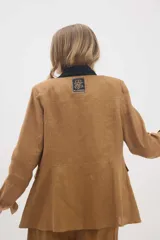 Chaqueta de lino marrón con cuello mao en contraste negro, cierre frontal con botones y hombreras.