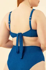 Soutien con aro color azul, breteles regulables, nudo en espalda y tela con textura a rayas.