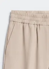Pantalón de corte recto y tiro medio, color beige, con cintura elástica y bolsillos laterales.