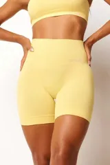 Short deportivo color amarillo, de tiro alto y corte ajustado. Confeccionado con tecnología seamless y textura acanalada en la cintura.