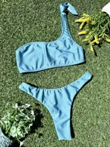 Bikini celeste de un hombro con bombacha entera colaless.