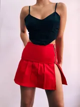 Minifalda tableada de bengalina color rojo, negro y blanco, con cierre metálico lateral.