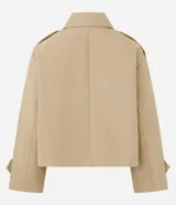 Trench coat corto de la marca Cortelle, confeccionado en una mezcla de algodón y poliéster con estructura de lona. Presenta un diseño de abotonado cruzado, cuello clásico, mangas largas con trabillas en los puños y bolsillos frontales.