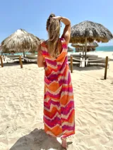 Vestido largo sin mangas de fibrana con estampado abstracto en tonos naranja, fucsia y beige.