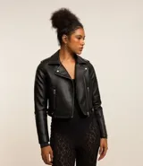 Campera estilo biker corta, color negro, confeccionada en poliuretano (PU) con cuello con solapa, cierre frontal de cremallera y bolsillos con cremallera.
