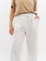 Pantalón de lino color blanco, de corte recto y holgado, con cintura elástica ajustable mediante cordón.