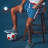 Short de jogging celeste con cintura elástica y cordón blanco. Tiene una franja vertical blanca y roja en los laterales.